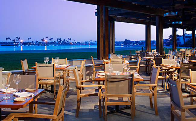 The outdoor dining area at Oceana Coastal Kitchen, one of the best San Diego restaurants with a view at the Catamaran Resort Hotel by Pacific Beach, San Diego