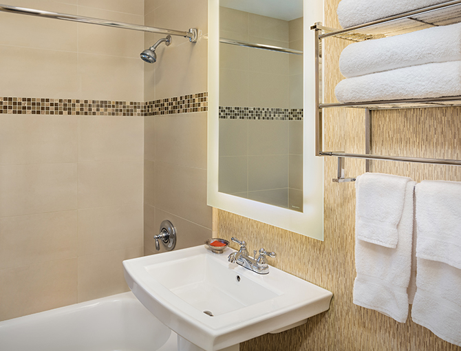 Bathroom with a sink and shower in a Garden View room at the Bahia Resort Hotel in Mission Beach, San Diego