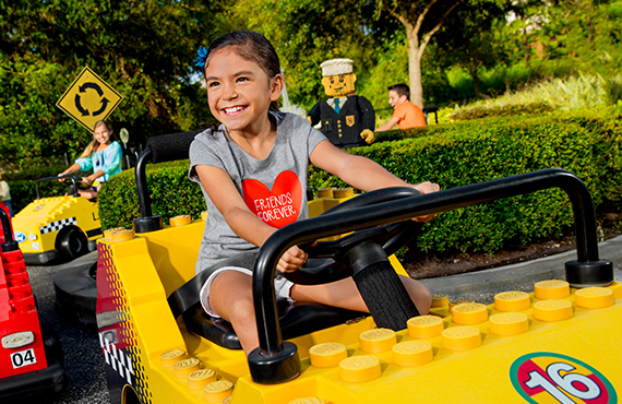 Young child driving Lego car