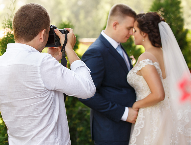 Professional photographer taking picture of wedding couple