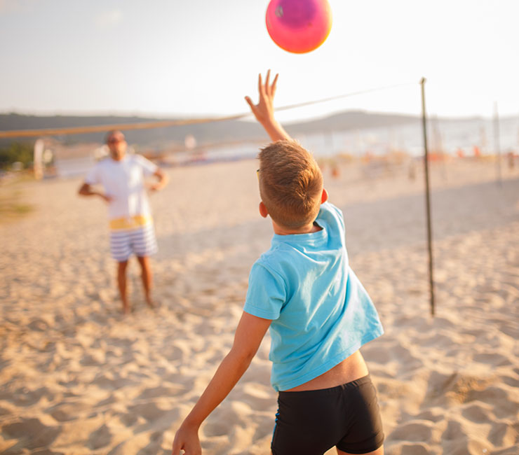 A family playing beach volleyball at the Bahia Resort Hotel beach on the shores of Mission Bay in San Diego.