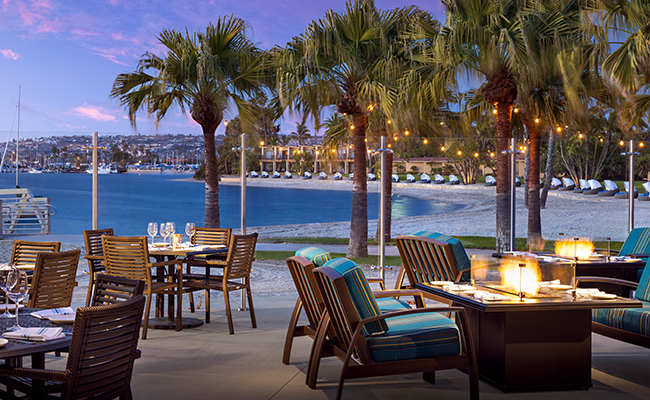 The view of Mission Bay at dusk from Dockside 1953's outdoor dining patio at the Bahia Resort Hotel in San Diego.