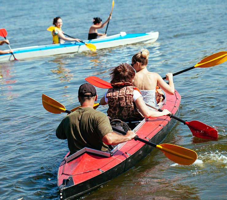 A group of adults kayaking during team building activities in San Diego at the Catamaran Resort Hotel.