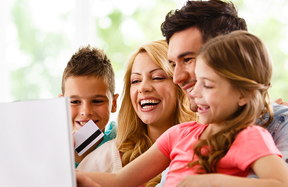 Family gathered around computer making vacation plans