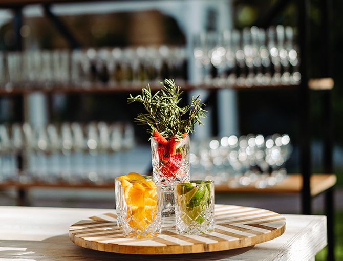 Close up of garnishes with outdoor bar in the background.