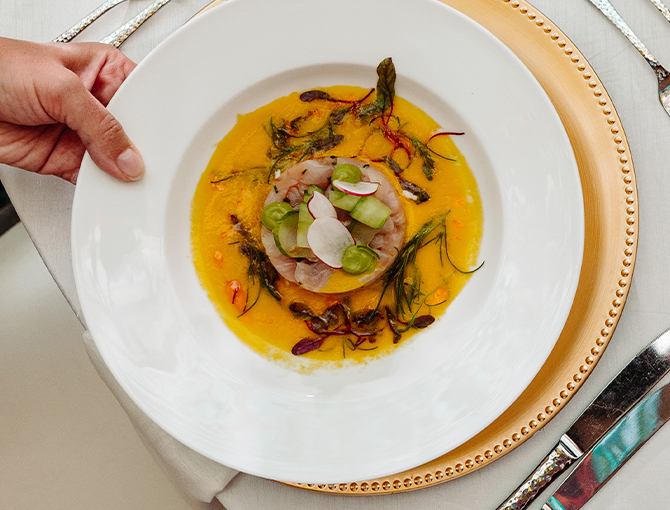 Serving a plated fish dish at a catered event at Bahia Resort