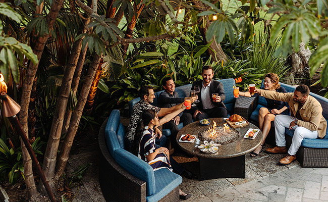 Group enjoying happy hour drinks and food at Moray's Lounge at the Catamaran Resort Hotel