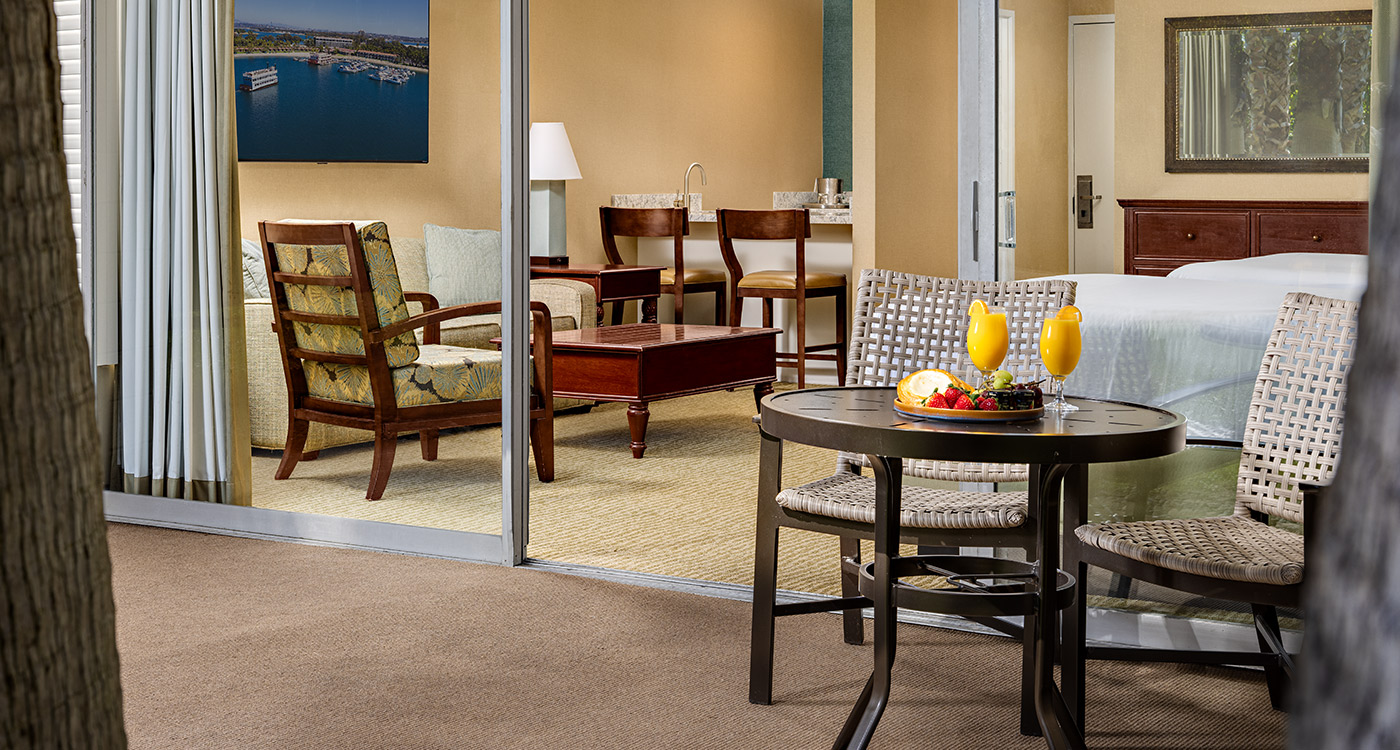 A wide view of a hotel room with a sitting area and a bed