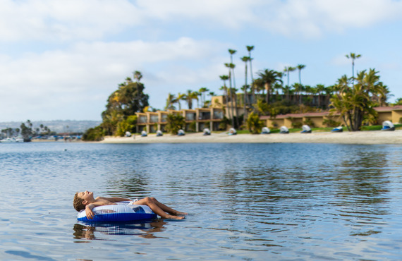 Boy floating on a floatie in the calm Mission Bay waters