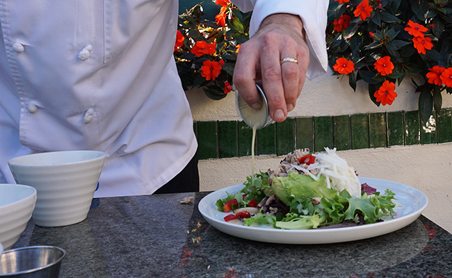 Dressing being poured over the Avocado Salad