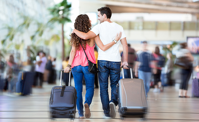 Engaged couple walking through airport