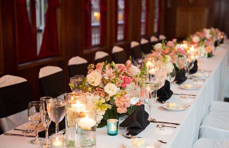 a long dining table set with flowers, candles, and wine glasses