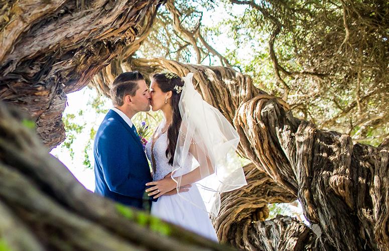 Wedding couple sharing a kiss in the tropical gardens at the Bahia Resort Hotel in San Diego.