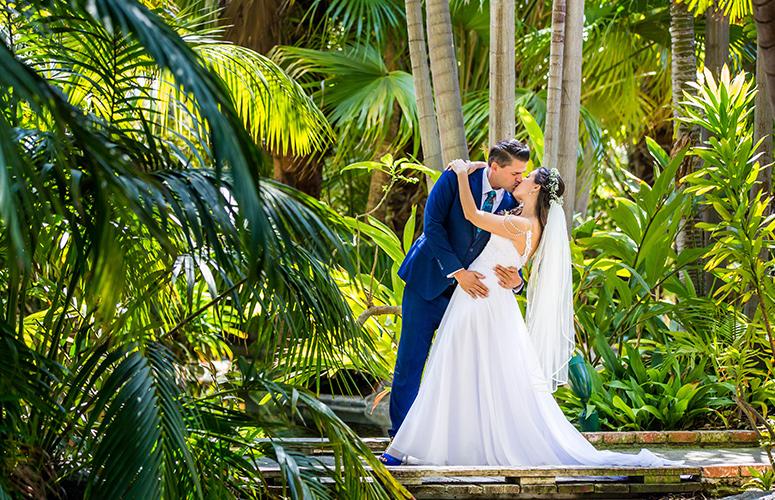 A couple kissing in the lush tropical gardens at the the Bahia Resort Hotel in San Diego