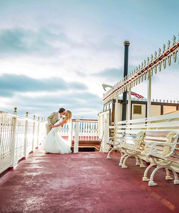 Bride and Groom kissing on the deck of the William D Evans private event boat on Mission Bay, San Diego.